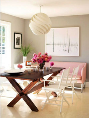 Sự tương phản giữa bàn ăn dã ngoại tối màu, ghế màu trắng và sofa hồng